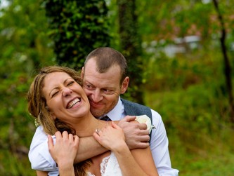 Bride and groom hugging and laughing under the tall trees, Sherry Pickerell photo